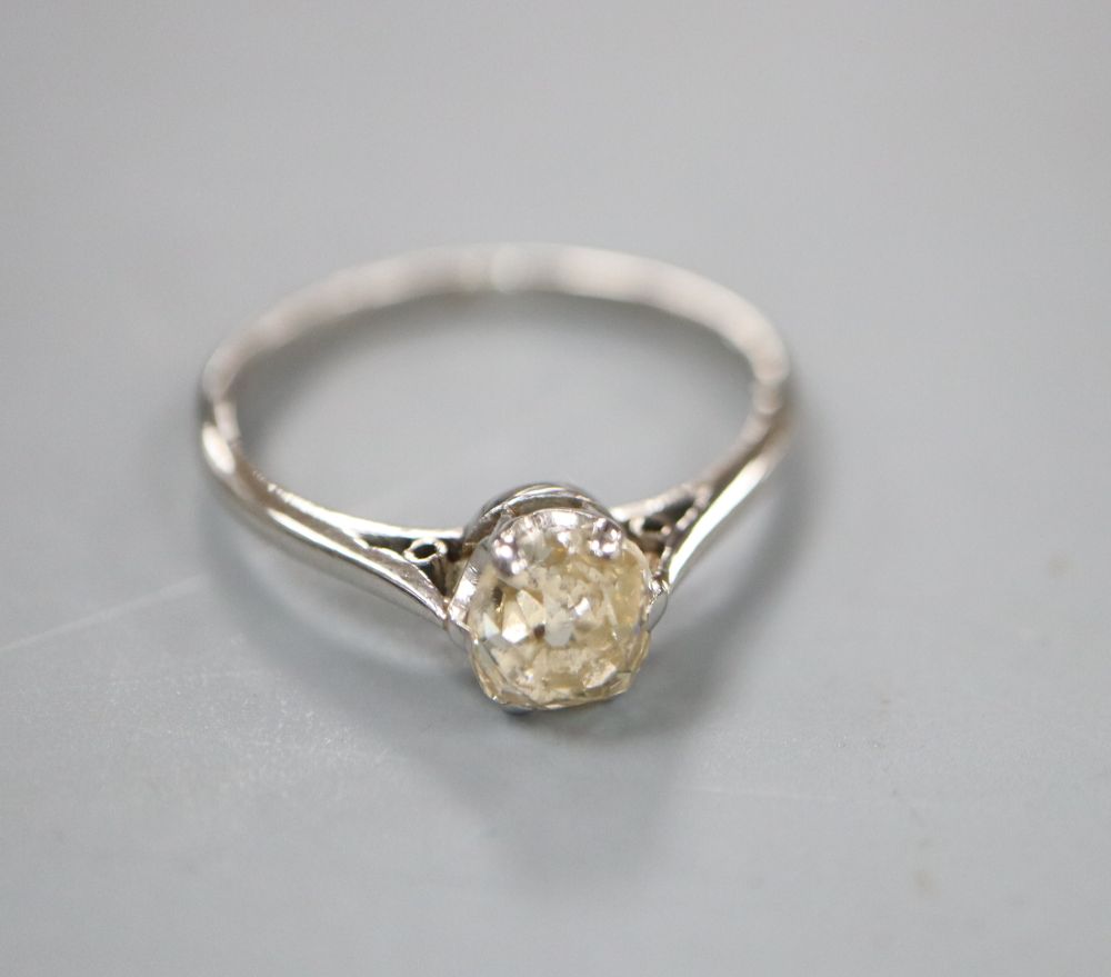 A white metal (stamped platinum) and diamond solitaire ring, size L, gross 2.4 grams.